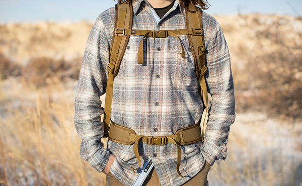 A person wearing the Guide's Edition Synapse 25 with the sternum strap buckled and using the optional padded hip belt.